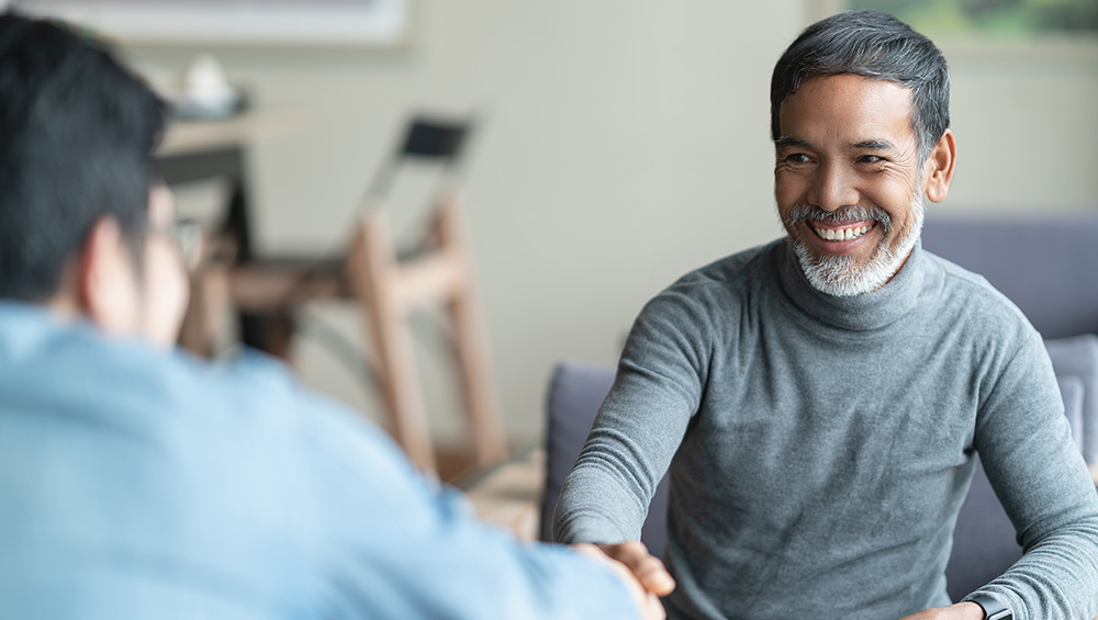 A senior man shaking hands with an advisor
