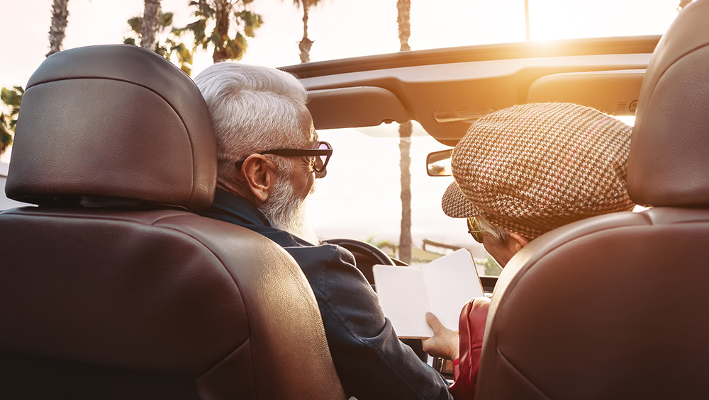 An elderly couple in a convertible car